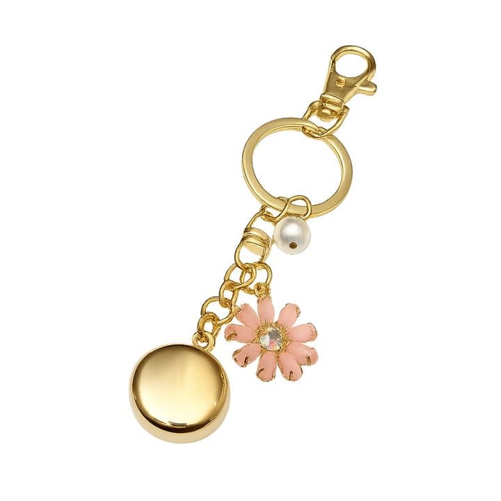 Gold invisaWear keychain with a round safety charm, a pink flower charm and a pearl