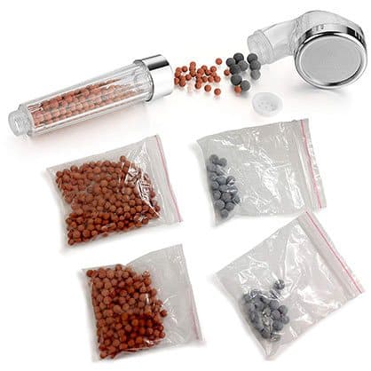 Clear shower handle with spilled orange and grey beads and four small bags of replacement beads, offered as an IOnic Spa add-on