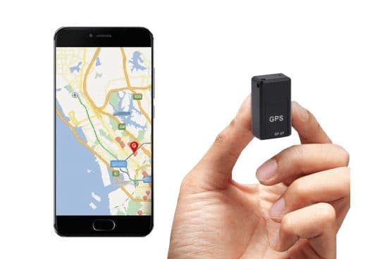 Small black box labelled GPS GF-07 held in a hand next to a smartphone showing a map with a location pin