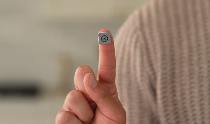 Small Jiffys pad stuck on a fingertip ready to wipe a screen
