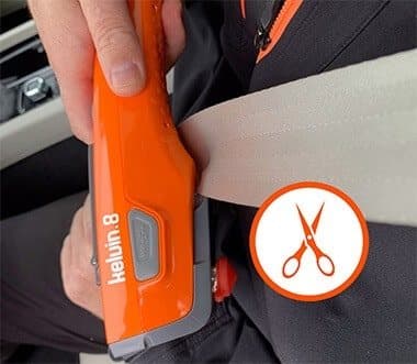 Hand using the Kelvin 8's recessed blade to cut a car seatbelt