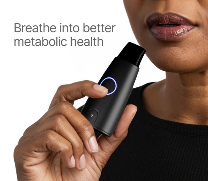 Close-up of a person breathing into the black Lumen device