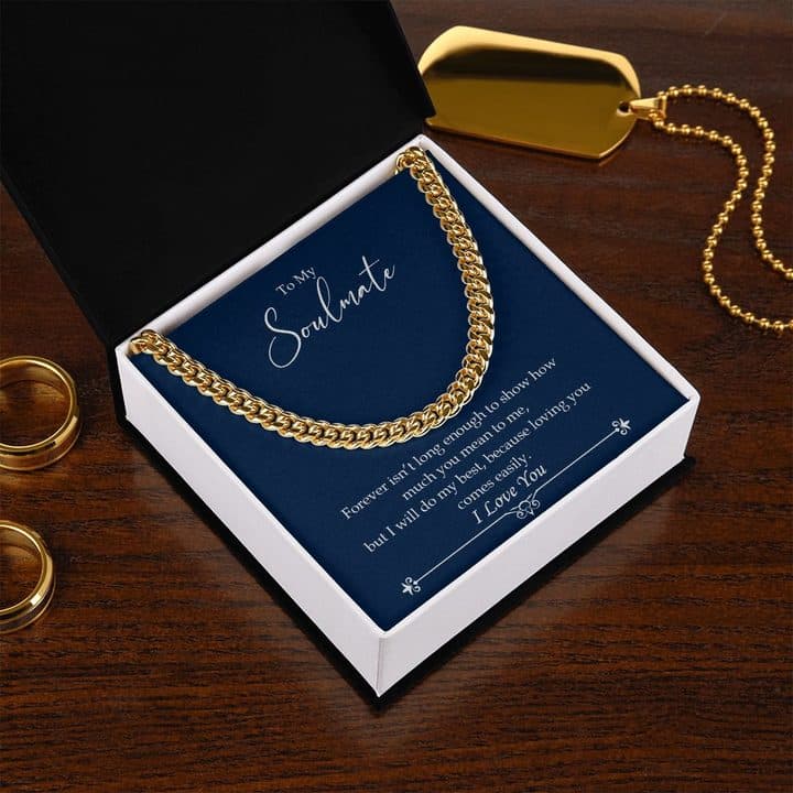 Gold-tone Luxury Cuban Link chain on the navy To My Soulmate card in an open box on a wooden table with gold rings and a dog tag