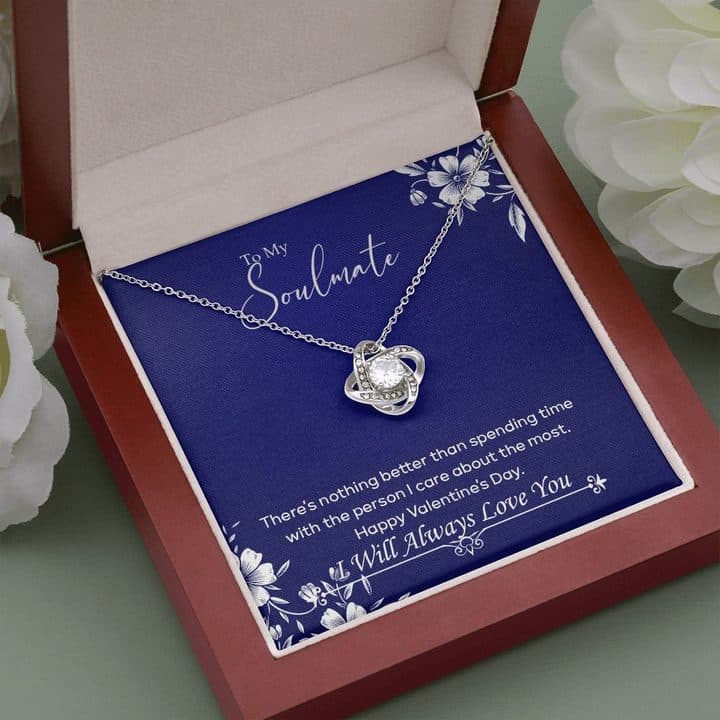 Silver-tone Luxury Love Knot on its navy To My Soulmate card inside an open red-brown mahogany-style box between white flowers