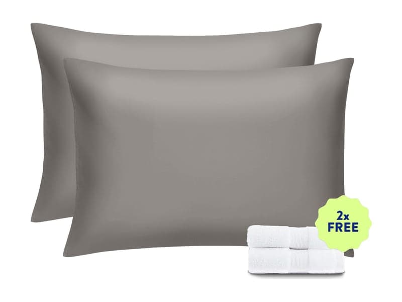 Two stone grey Miracle Made pillowcases on pillows with a folded white washcloth and a 2x free badge, as shown on the offer page
