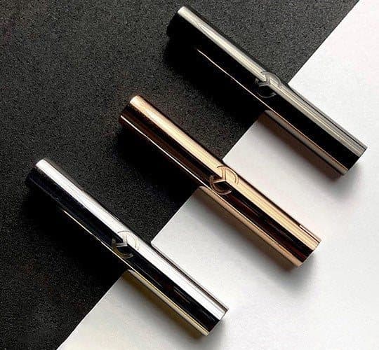 Three Moksha Beam pendants in silver, rose gold and space grey on a black and white background