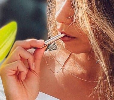 Woman breathing out through a rose gold Moksha Beam held to her lips