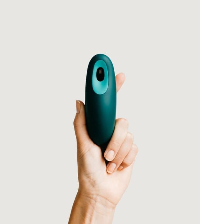 Hand holding the teal Moonbird device upright against a plain background