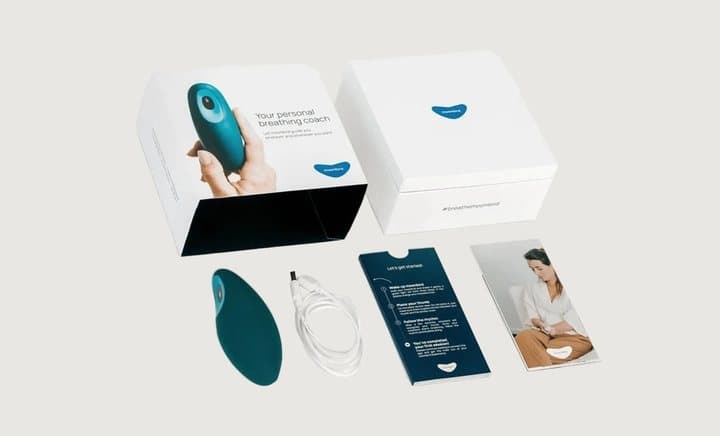 Moonbird box opened to show the teal device, charging cable, quick start guide and leaflets