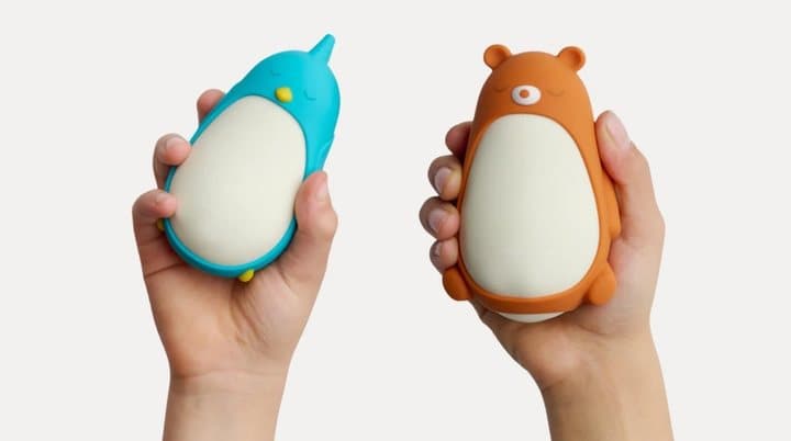 Two hands holding Moonbuddy in the blue Bibi the Bird sleeve and the orange Barry the Bear sleeve