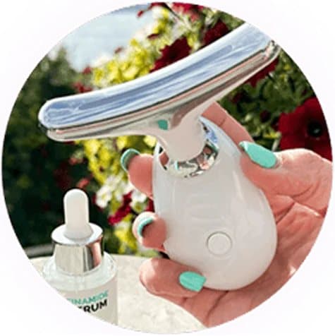 Hand holding MyoGlow next to a bottle of serum on an outdoor table
