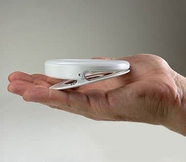 White OlumiRing ring light resting in the palm of a hand to show its size