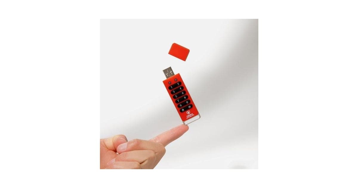 Red Omni DataSafe keypad USB drive balanced on a fingertip with its cap above it