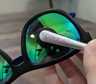 Peeps cleaner pads on a mirrored green sunglasses lens