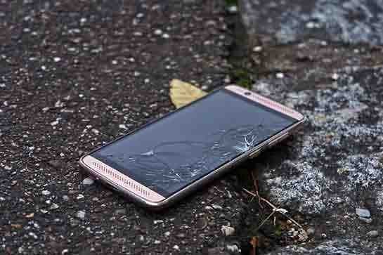 Smartphone with a cracked screen lying on a road, from ThePhotoStick Mobile page