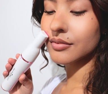 Woman holding the Pluxy epilator against her upper lip