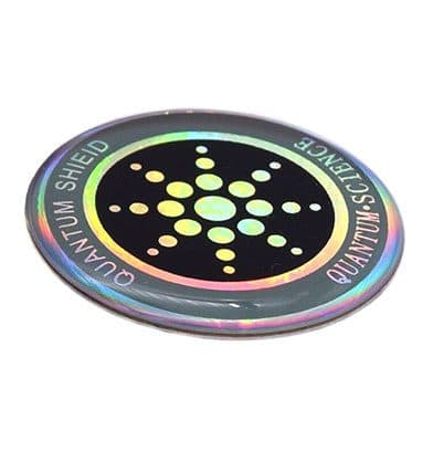 Round holographic sticker with a black centre and dotted star pattern, edged with the words Quantum Shield and Quantum Science