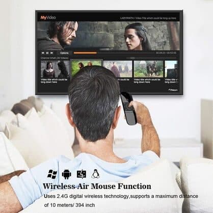 Man on a sofa pointing the RemoteX Pro at a TV showing a video app, with the heading wireless air mouse function and a 10 metre range claim