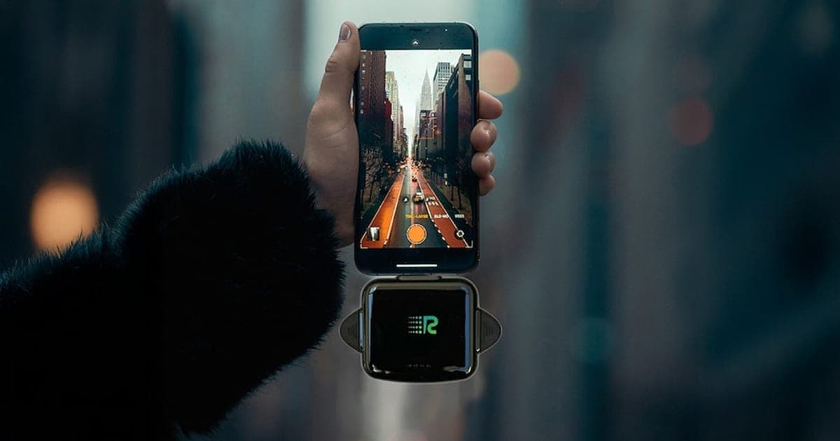 Black Rush Charge Universe plugged into the bottom of a smartphone held in a hand on a city street