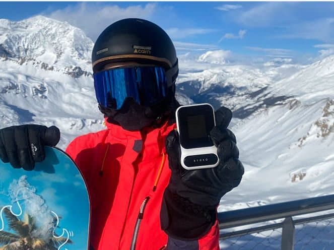 Skier on a mountain holding a Ryoko PRO hotspot