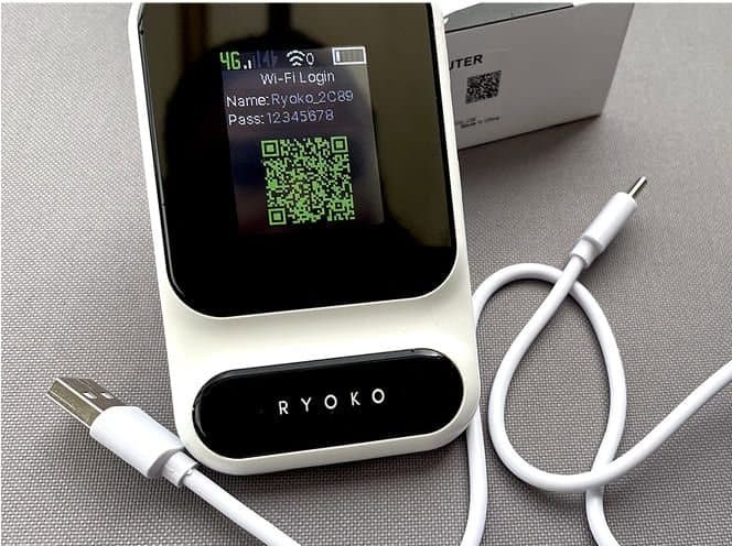 Ryoko PRO hotspot showing a Wi-Fi QR code on its screen next to a USB-C cable