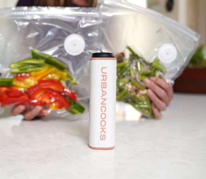 SealPro next to two zip-top vacuum bags of peppers and green beans
