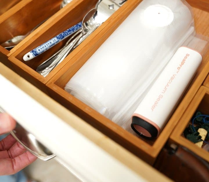 SealPro vacuum sealer stored in a kitchen drawer beside utensils
