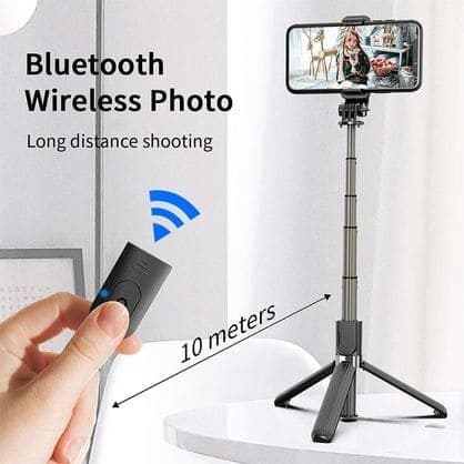 Selfie stick on tripod legs holding a phone, with a hand pressing a small black remote and the words Bluetooth wireless photo, long distance shooting, 10 meters