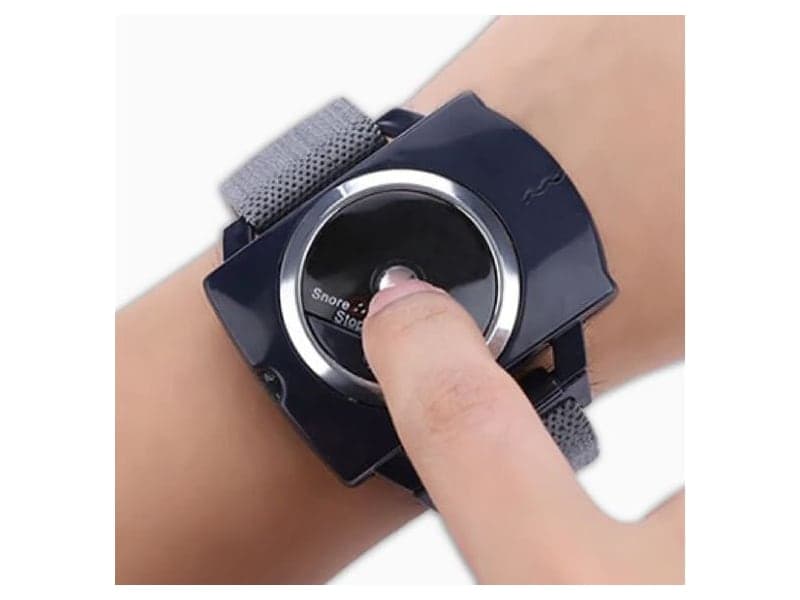 A finger pressing the central button on the Sleep Connection wristband, next to the word Test