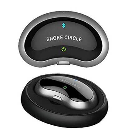 Oval anti-snoring unit marked Snore Circle above the same unit sitting in a black round charging dock, used for the SleepLab dock add-on
