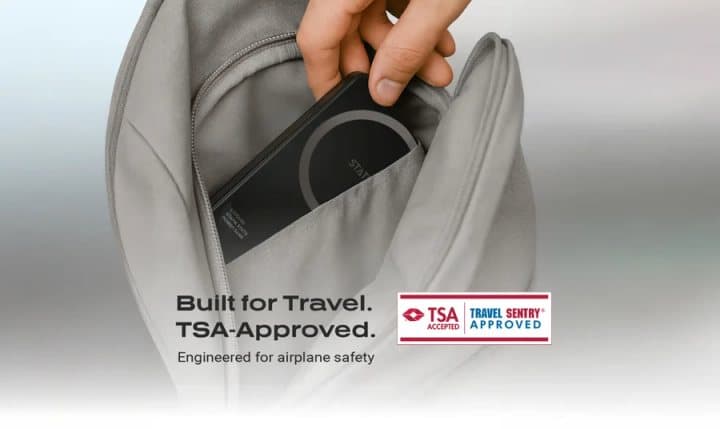 Hand putting a Statik State power bank into a bag, with text built for travel and a TSA-approved badge