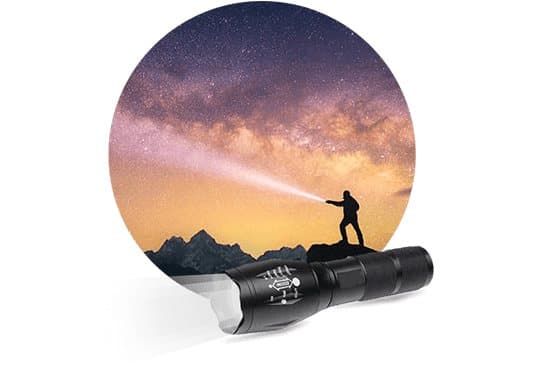 TacticalX flashlight in front of an image of a person on a rock shining a beam into a starry night sky