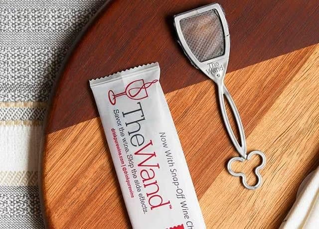 Individually wrapped PureWine wand packet next to an unwrapped wand on a wooden board