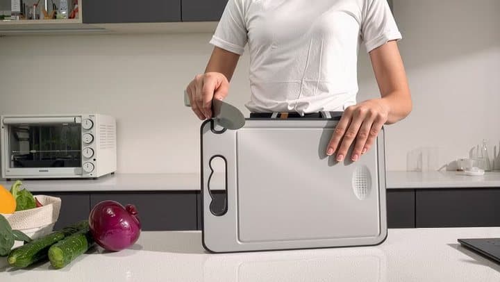 Person drawing a knife through the sharpener built into the corner of a TIBO cutting board