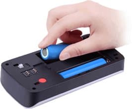 Hand inserting blue cylindrical batteries into the back of a video doorbell, illustrating the Battery or Existing Wire Power Option add-on