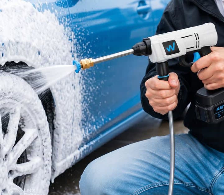 Person spraying foam onto a blue car with a WashUpGo washer