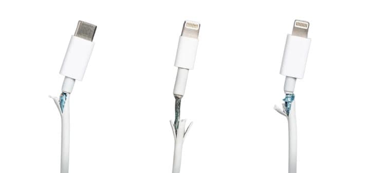 Three white charging cables with frayed, split ends near the connectors