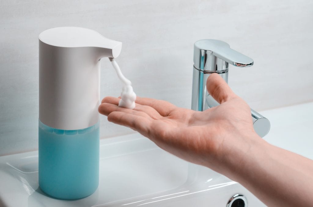 A person using the Automatic Soap Dispenser to wash his hands.